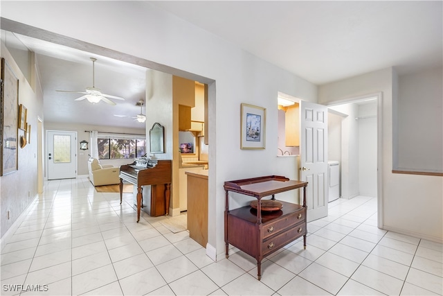 hallway featuring washer / dryer and light tile patterned floors