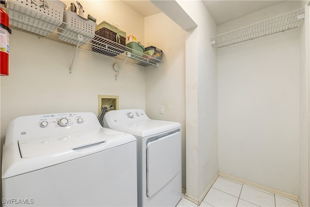 laundry room featuring separate washer and dryer and light tile patterned flooring