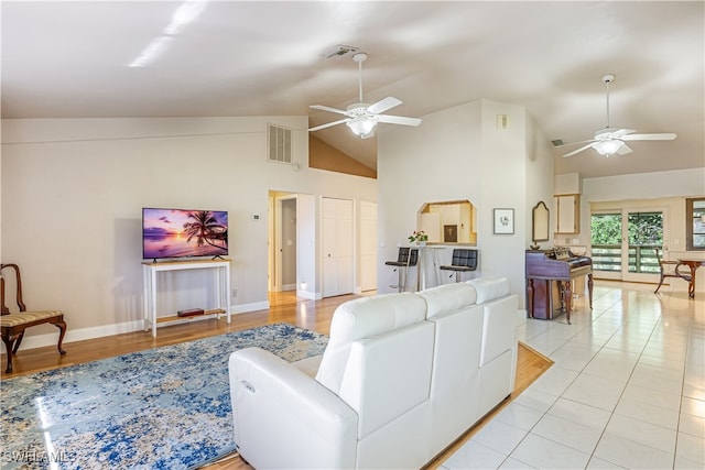 tiled living room with high vaulted ceiling and ceiling fan