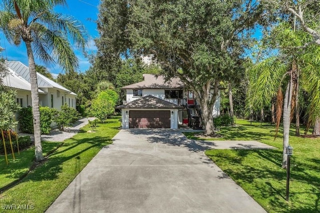 view of front facade featuring a garage, a front yard, and an outbuilding