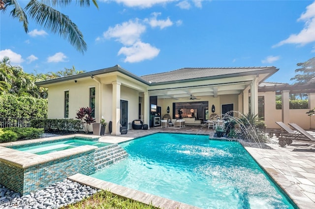 view of swimming pool featuring pool water feature, ceiling fan, an in ground hot tub, and a patio