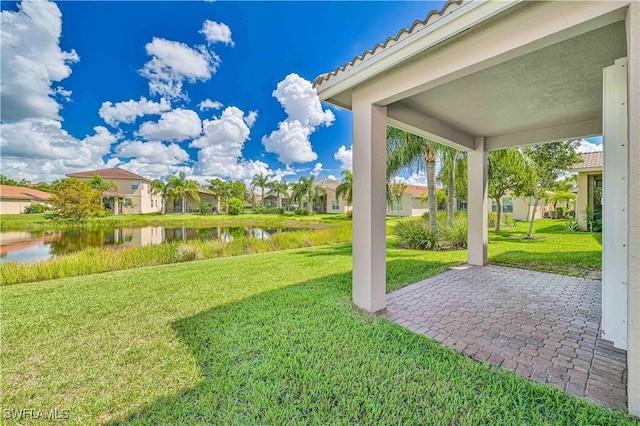 view of yard featuring a water view and a patio