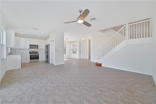 unfurnished living room with ceiling fan, sink, and light tile patterned flooring