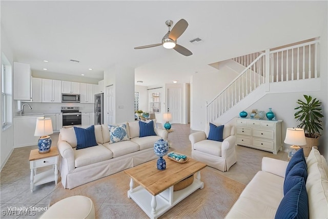 living room with light tile patterned floors, ceiling fan, and sink