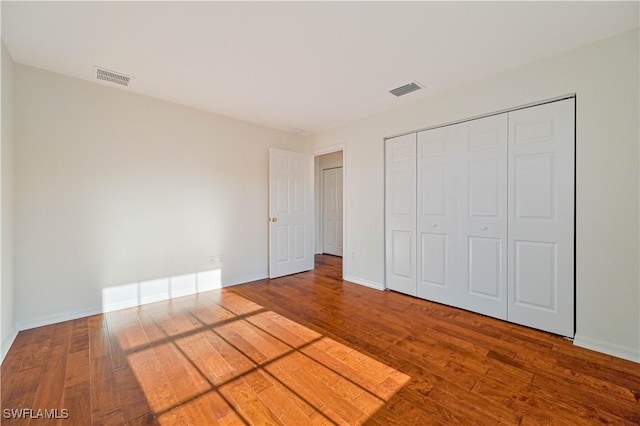 unfurnished bedroom with wood-type flooring and a closet