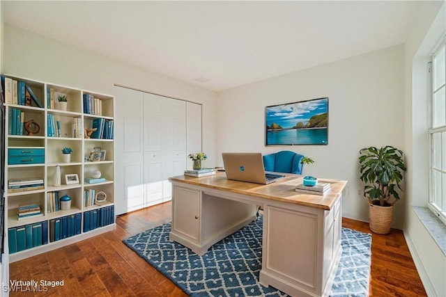 home office with plenty of natural light and dark hardwood / wood-style floors