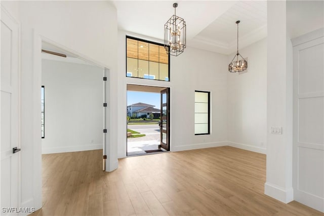 entrance foyer featuring light hardwood / wood-style flooring and a notable chandelier