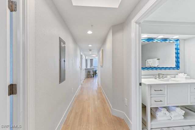 hallway with sink and light hardwood / wood-style floors