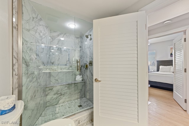 bathroom with a shower with shower door and hardwood / wood-style floors