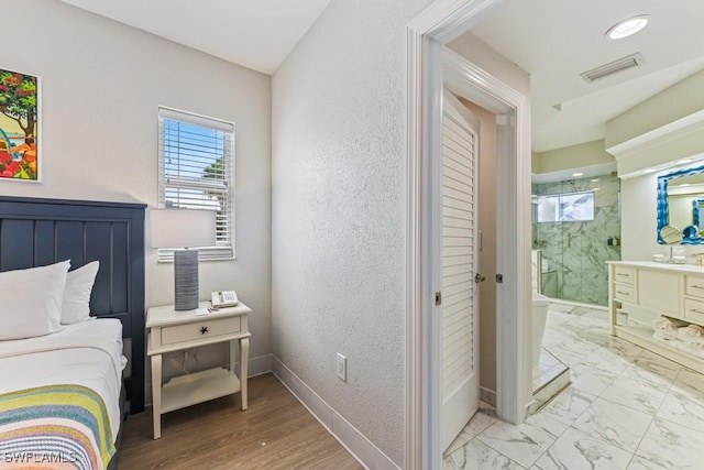 200 Estero Blvd Unit 101, Fort Myers Beach, FL 33931 - bedroom featuring visible vents, baseboards, ensuite bathroom, a textured wall, and marble finish floor