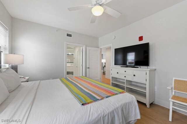 bedroom with light wood-type flooring, connected bathroom, and ceiling fan