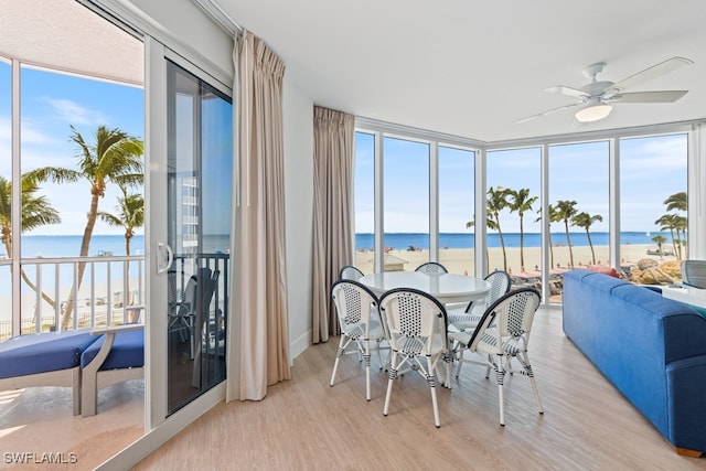 sunroom featuring a water view, ceiling fan, and a wealth of natural light