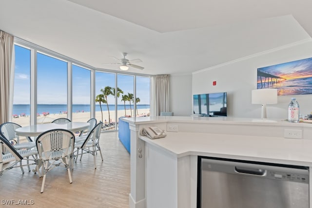 kitchen featuring dishwasher, floor to ceiling windows, light hardwood / wood-style floors, ceiling fan, and a water view