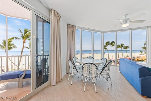 sunroom featuring a water view, ceiling fan, and a healthy amount of sunlight