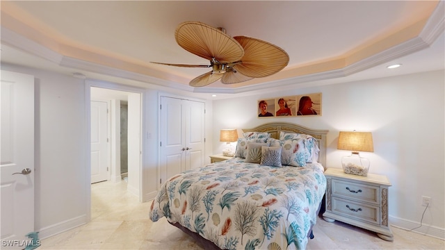 bedroom featuring a closet, a tray ceiling, and ceiling fan