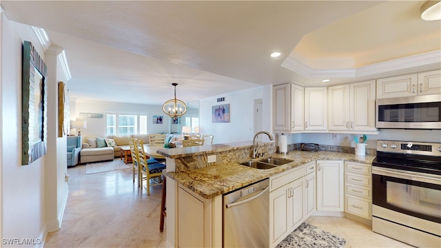 kitchen featuring light stone counters, stainless steel appliances, sink, a kitchen breakfast bar, and kitchen peninsula