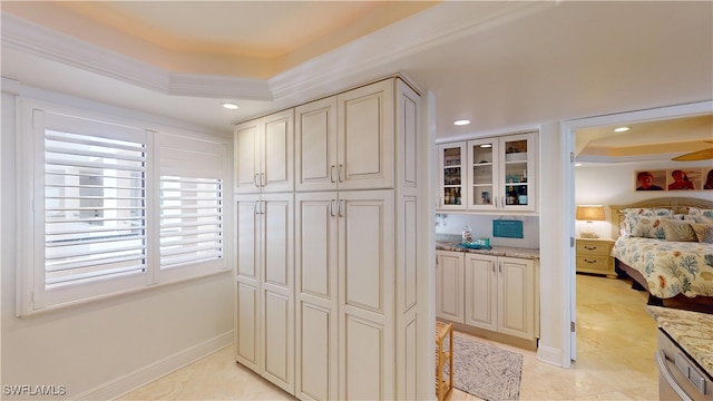 interior space featuring dishwasher, light stone counters, and a tray ceiling