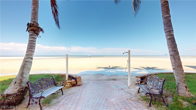 view of patio featuring a water view and a beach view