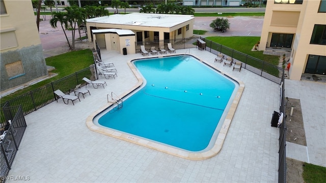 view of swimming pool with a lawn and a patio