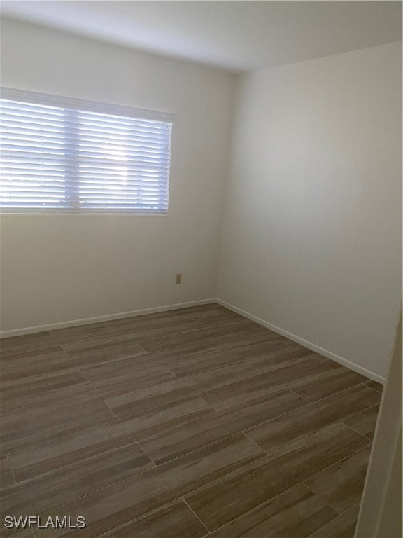 empty room featuring baseboards and wood finish floors