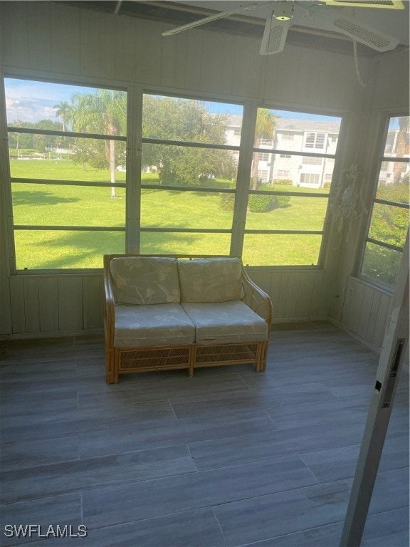 unfurnished sunroom featuring a ceiling fan and a wealth of natural light