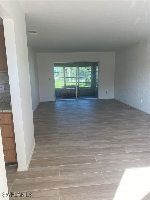 spare room with wood finish floors and visible vents