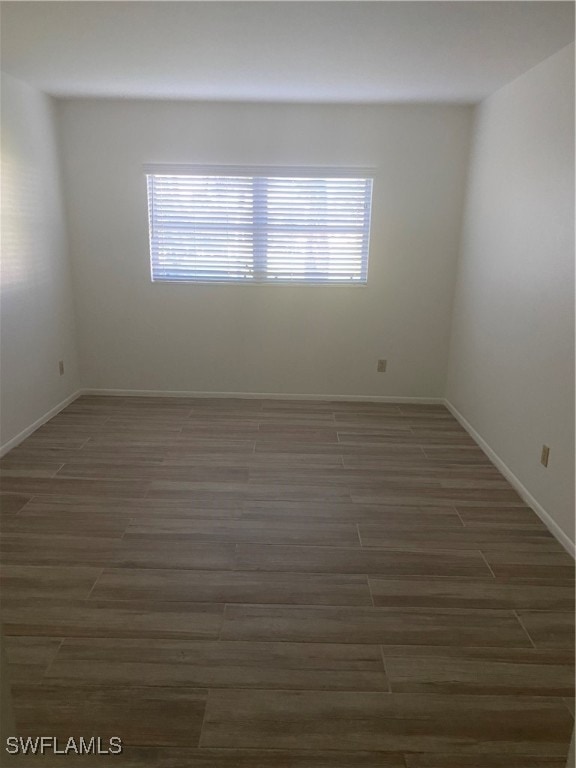 unfurnished room featuring baseboards and wood finished floors