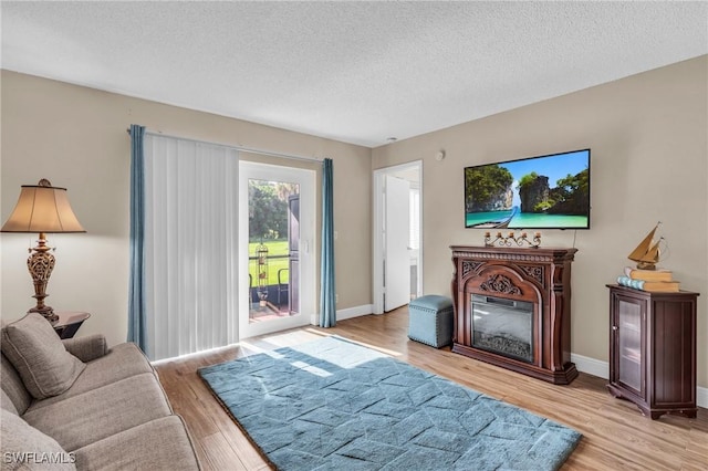 living room featuring light hardwood / wood-style floors and a textured ceiling