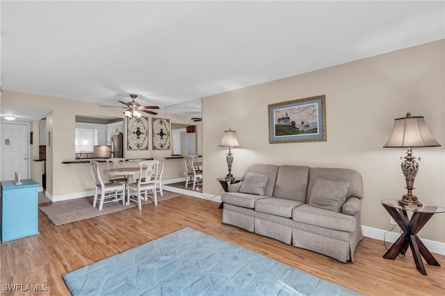 living room featuring light hardwood / wood-style flooring and ceiling fan