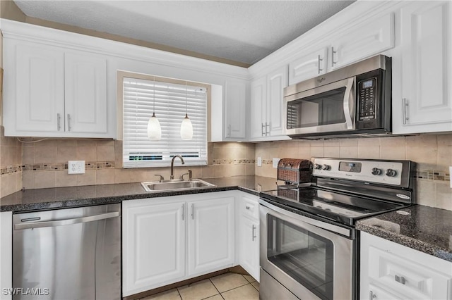 kitchen with white cabinetry, sink, stainless steel appliances, a textured ceiling, and light tile patterned flooring