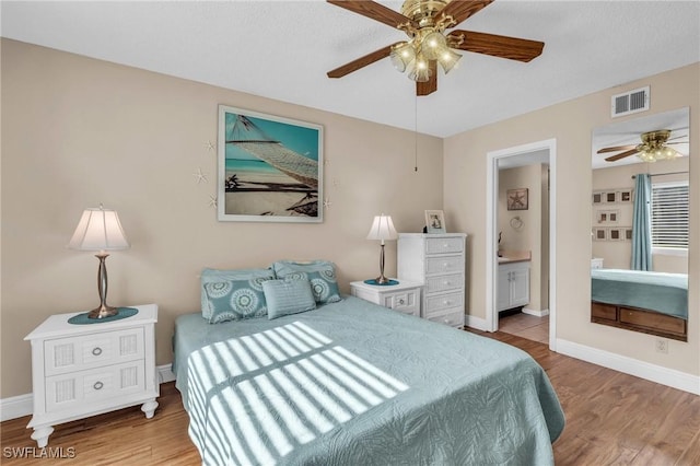 bedroom featuring connected bathroom, ceiling fan, and wood-type flooring