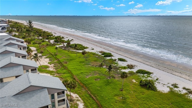 birds eye view of property featuring a water view and a beach view