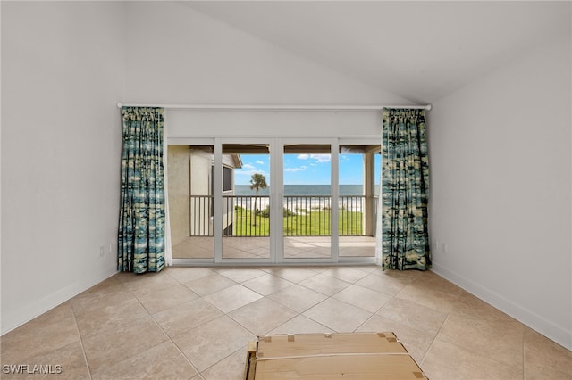 tiled empty room featuring high vaulted ceiling