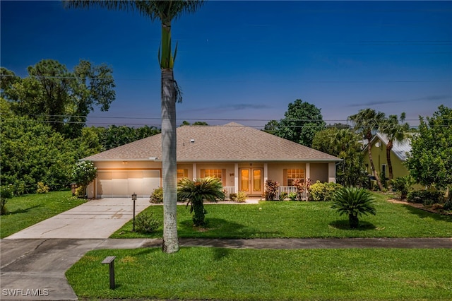 single story home featuring a lawn, a garage, and covered porch