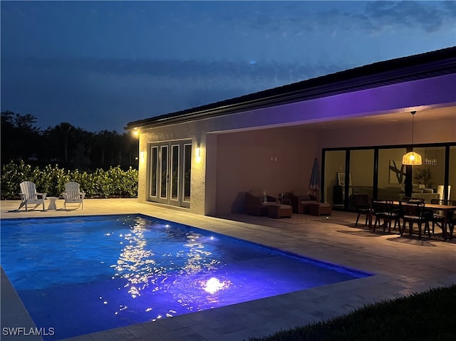 view of swimming pool with a patio and french doors