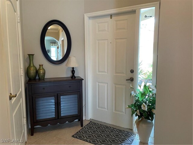 tiled entryway featuring ornamental molding