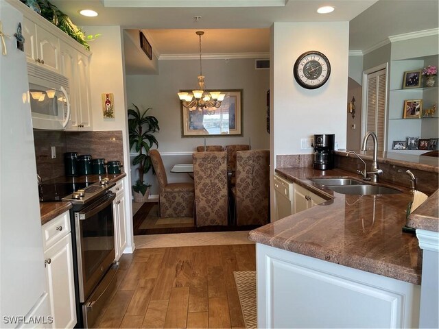 kitchen featuring pendant lighting, sink, white cabinets, hardwood / wood-style flooring, and stainless steel electric range