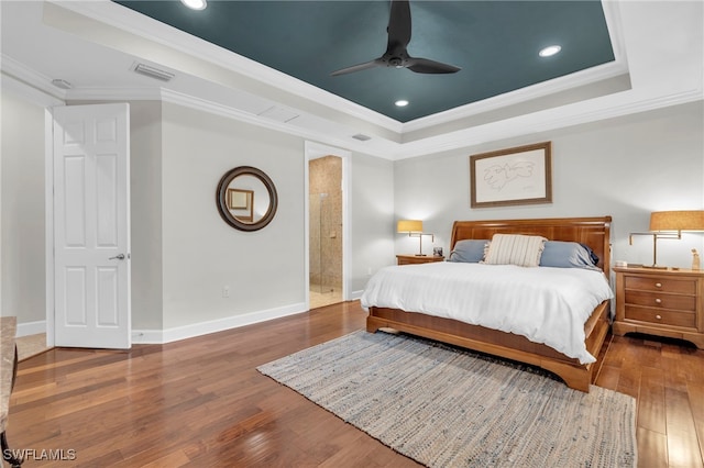 bedroom featuring hardwood / wood-style floors, ceiling fan, a raised ceiling, and ornamental molding