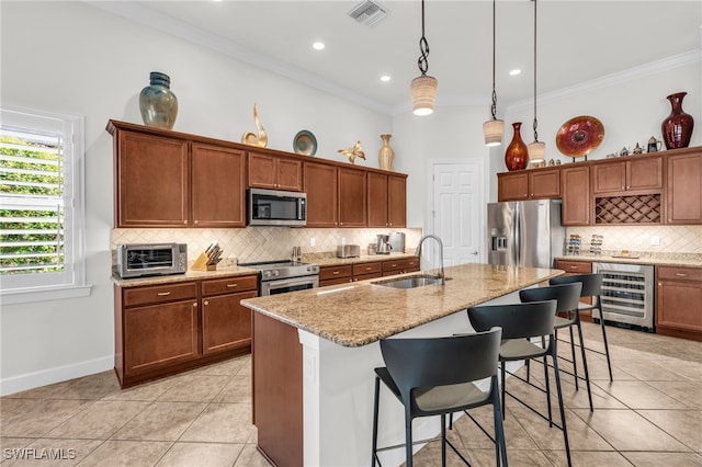 kitchen with a center island with sink, stainless steel appliances, wine cooler, hanging light fixtures, and sink