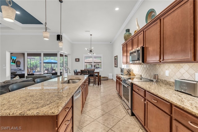 kitchen with stainless steel appliances, crown molding, an island with sink, and sink