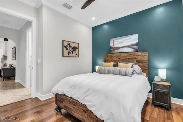 bedroom featuring ornamental molding, dark hardwood / wood-style flooring, and ceiling fan