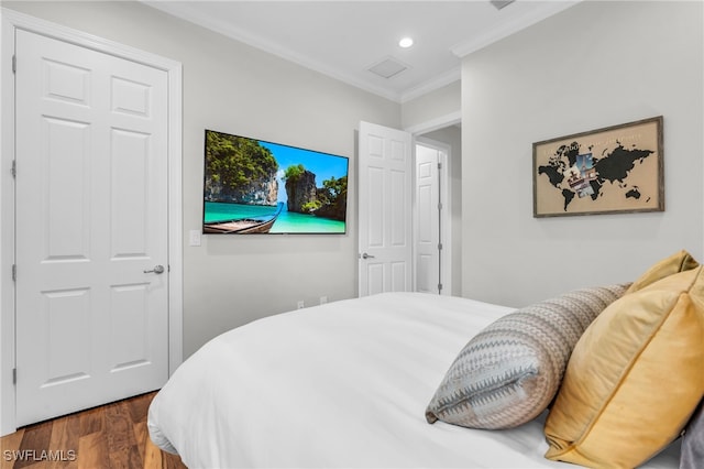 bedroom with dark wood-type flooring, a closet, and ornamental molding