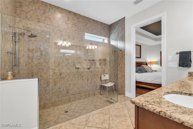 bathroom with tile patterned flooring, vanity, and a tile shower