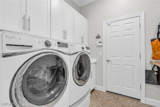 washroom featuring cabinets, light tile patterned flooring, and washer and clothes dryer