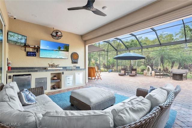 view of patio / terrace featuring a lanai, area for grilling, sink, and ceiling fan