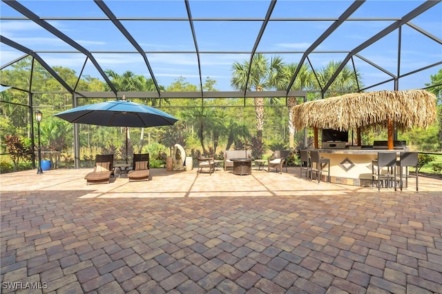 view of patio / terrace featuring a bar and glass enclosure