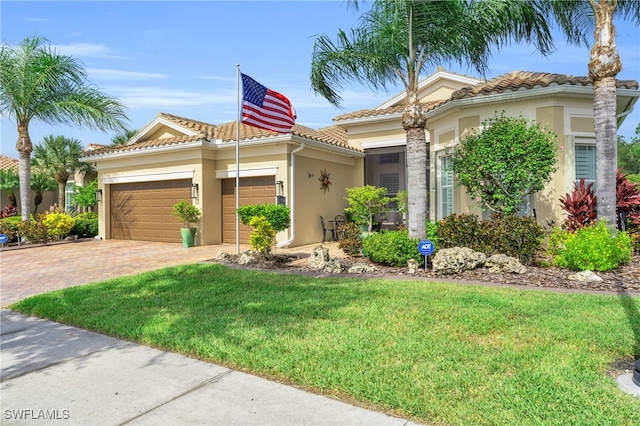 mediterranean / spanish-style home featuring a garage and a front yard