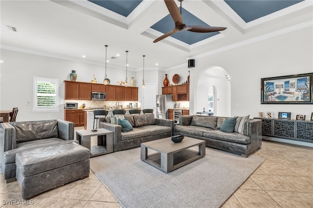 tiled living room featuring beamed ceiling, ceiling fan, crown molding, and coffered ceiling