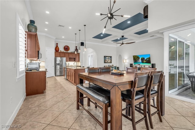 tiled dining area with crown molding, coffered ceiling, sink, beamed ceiling, and ceiling fan with notable chandelier