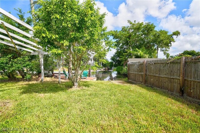 view of yard featuring a water view and a pergola